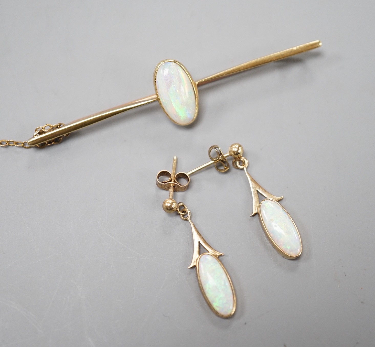 A 15ct and white opal set bar brooch, 60mm and a pair of yellow metal and white opal set drop earrings, gross weight 5.3 grams.